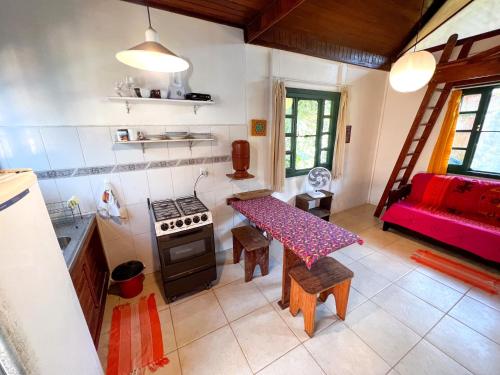 a kitchen and living room with a table and a couch at Condomínio Aldeia in Abraão