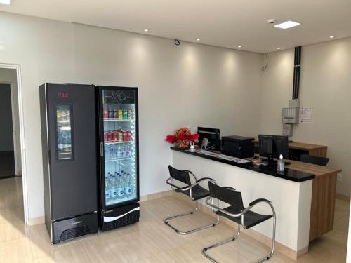 a bar with two chairs and a drink cooler at Urupês Hotel in Urupês