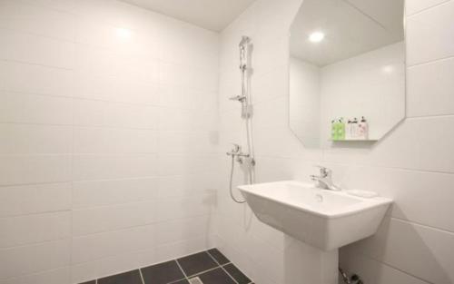 a white bathroom with a sink and a shower at Hotel Days A in Busan