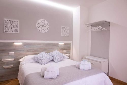 een witte slaapkamer met een bed met handdoeken erop bij Tra la Terra e le Stelle in Assisi