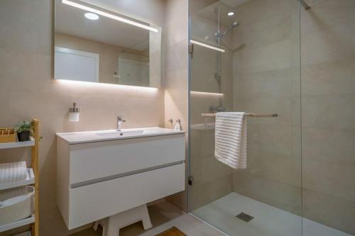 La salle de bains est pourvue d'un lavabo et d'une douche. dans l'établissement Heerlijk penthouse, dakterras met prachtig zeezicht, kingsize bed, zwembad, 700m van strand, à Torre de Benagalbón