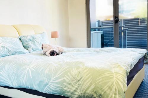 a large bed with a stuffed animal laying on it at New Comfy stylish Apt in Rhodes Next to train n shopping center in Sydney