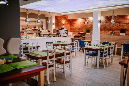 Un restaurante con mesas y sillas y una cocina. en Willa Plażowa, en Międzyzdroje