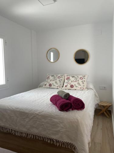una camera da letto con un letto e due asciugamani di Apartamento turístico Ático La Piterilla a Huelva