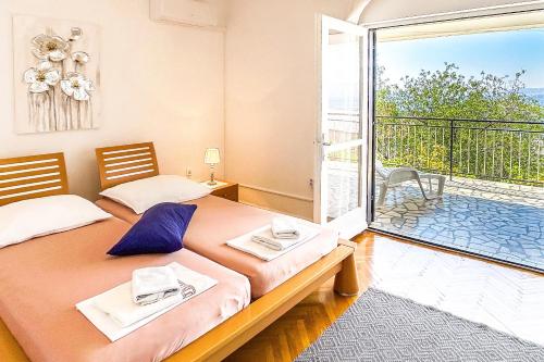 a bedroom with two beds and a balcony at Zimmer - Room - Magdalena in Senj
