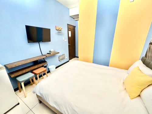 a bedroom with a bed and a tv on a wall at 莫蘭狄 in Taichung