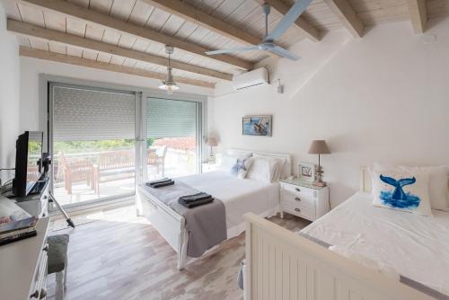 um quarto com uma cama, uma televisão e uma janela em Studio 2 δωματίων στο Μεριστό, κοντά στο λιμάνι em Egina
