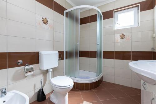 a bathroom with a toilet and a shower and a sink at Apartment Dragan i Slavica in Lopar