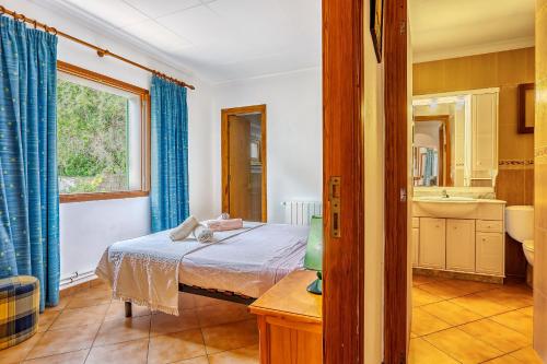 Schlafzimmer mit einem Bett, einem Fenster und einem Waschbecken in der Unterkunft Casa Sergi mit kleinem Pool und Wifi in Cala Llombards