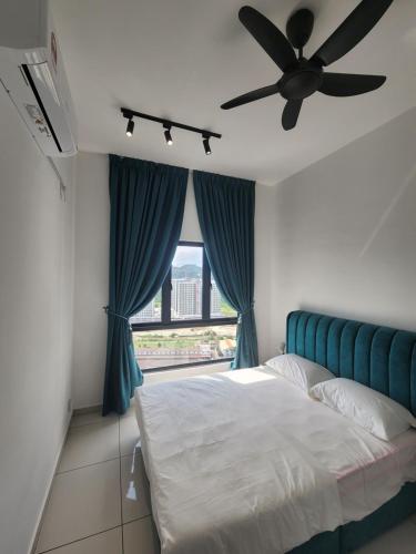 a bedroom with a bed with a fan and a window at The Horizon - Ipoh in Ipoh