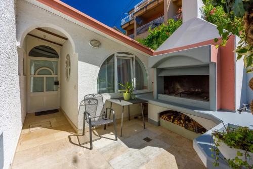 a patio with a fireplace and a table and chairs at Apartmani Višnja in Crikvenica