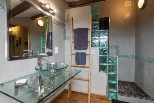 a bathroom with a glass sink and a shower at Mas de l’église in Aubussargues