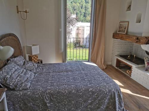 a bedroom with a bed and a large window at Chalet 1900, gîte de caractère in Nescus
