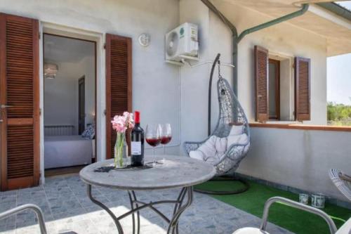 a table with two glasses of wine and a chair at a casa di Sara in Sassari