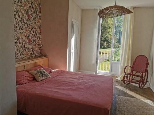 a bedroom with a bed and a chair and a window at Chalet 1900, gîte de caractère in Nescus