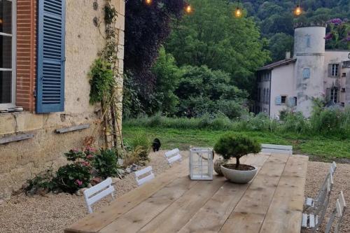 a wooden table with a potted tree on a patio at Chalet 1900, gîte de caractère 