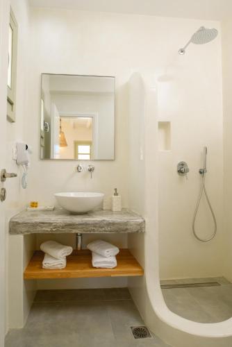 Baño blanco con lavabo y espejo en ERISIMO SUITES, en Egíali