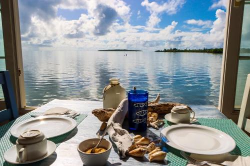 uma mesa com pratos de comida e vista para a água em CHILLpill Guest House em Mahébourg