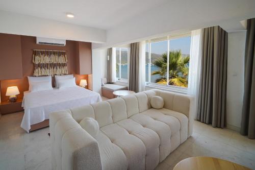 a hotel room with a couch and a bed and a window at Bono Residence in Marmaris