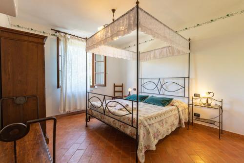 a bedroom with a four poster bed with a canopy at Appartamento Moraiolo in Montepulciano