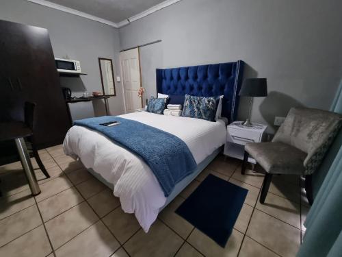 una camera con un grande letto e una sedia di Monate BNB a Kuruman