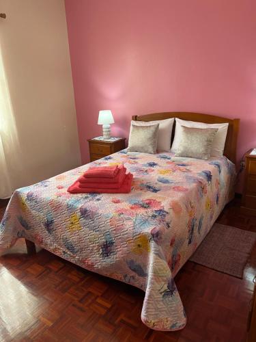 una camera da letto con un letto con un piumone colorato di Vivenda da Praia a Machico