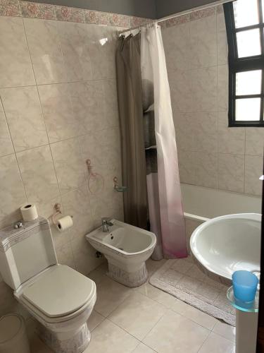 La salle de bains est pourvue de toilettes, d'une baignoire et d'un lavabo. dans l'établissement Vivenda da Praia, à Machico