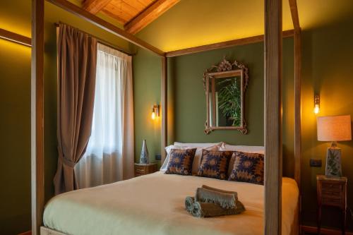 a bedroom with a canopy bed and a mirror at La Lupa La Morra in La Morra
