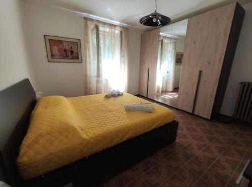 - une chambre avec un lit jaune et un miroir dans l'établissement Casa Anselmi, à Abbadia San Salvatore