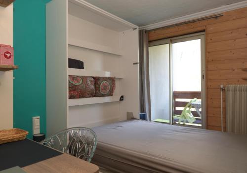 a bedroom with a bed and a table and a window at Studio à Courchevel Moriond in Saint-Bon-Tarentaise