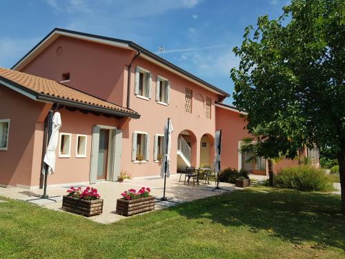 a pink house with two umbrellas in a yard at Agriturismo Casa Rossa in Postioma