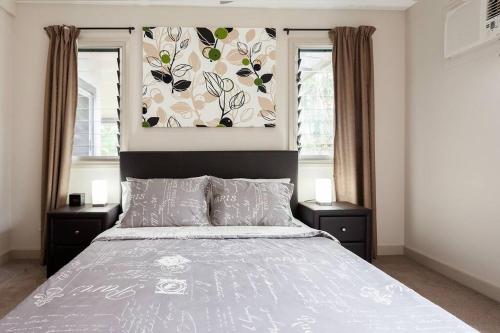 a bedroom with a large bed with two windows at Modern & Cosy Granny Flat in Cairns-WiFi included in Edge Hill