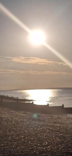 a sunset on a beach with the ocean at Ashdale By Sea in Whitstable