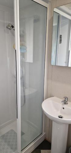 a bathroom with a glass shower and a sink at Ashdale By Sea in Whitstable
