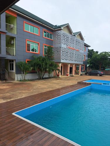 a house with a swimming pool in front of a building at Dreamers Lodge in Prampram