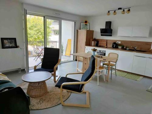 ein Wohnzimmer mit einem Tisch und Stühlen sowie eine Küche in der Unterkunft Appartement neuf T2 in Saint-Pierre-Quiberon