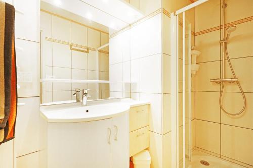 a white bathroom with a sink and a shower at Aux Flocons de la Mauselaine - Station de ski in Gérardmer