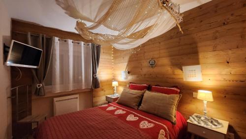 a bedroom with a red bed and wooden walls at Aux Flocons de la Mauselaine - Station de ski in Gérardmer