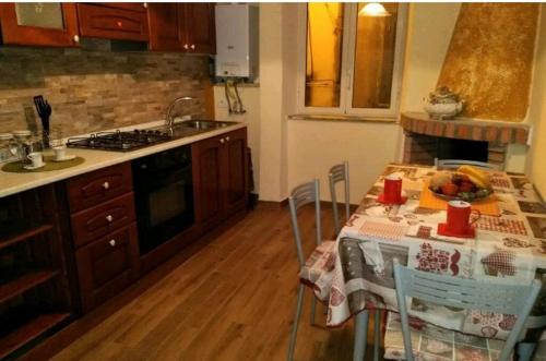 eine Küche mit einem Tisch mit Stühlen und einem Waschbecken in der Unterkunft Casa Sgurghy in Sgurgola