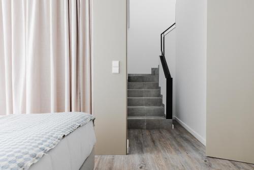 a bedroom with a bed and a staircase at Memmo Baleeira - Design Hotels in Sagres