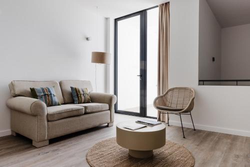 a living room with a couch and a chair at Memmo Baleeira - Design Hotels in Sagres