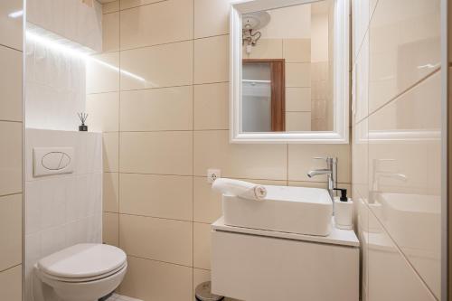 een witte badkamer met een toilet en een wastafel bij K7 - Boutique Apartments, Best Location. By BQA in Boedapest