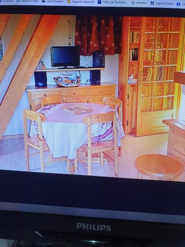 un écran de télévision montrant une cuisine avec une table et des chaises dans l'établissement Catarmina, à Saint-Pancrace