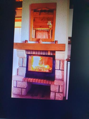 a brick fireplace in a kitchen with a window at Catarmina in Saint-Pancrace