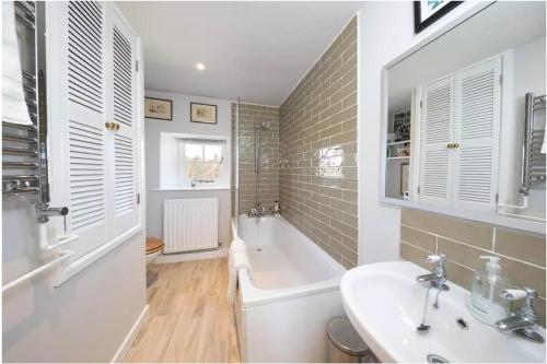Coves House Farm B&B في Wolsingham: حمام مع حوض ومغسلة وحوض استحمام