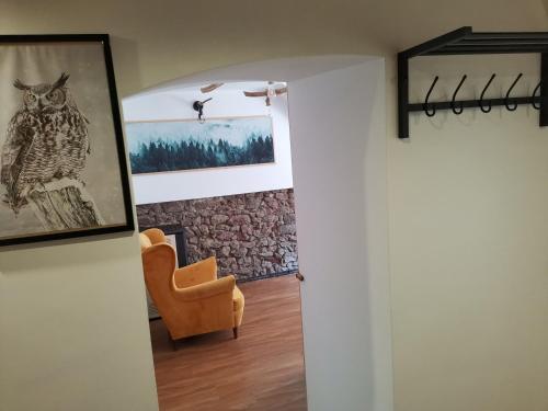 a room with a chair and a picture of an owl at Przystanek Srebrna Góra in Srebrna Góra