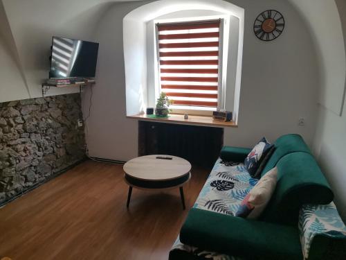 uma sala de estar com um sofá verde e uma janela em Przystanek Srebrna Góra em Srebrna Góra