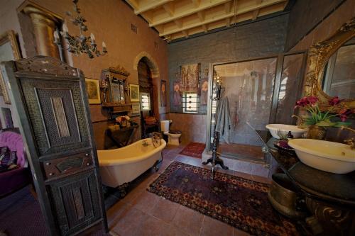 een grote badkamer met een bad en 2 wastafels bij Bygracealone Manor in Outeniekwa