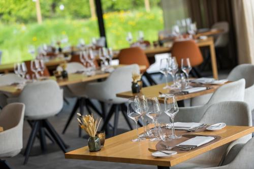 a row of tables and chairs with wine glasses on them at Martin's Rentmeesterij in Bilzen