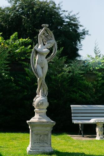 a statue of a woman on a pedestal in a park at Muller Hotel Boutique & Spa in Galaţi
